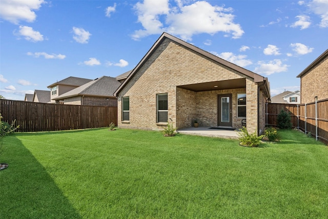 back of house featuring a lawn and a patio