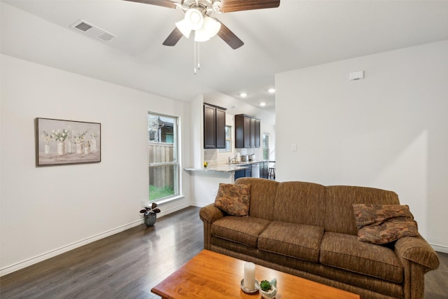 living room with dark hardwood / wood-style flooring and ceiling fan