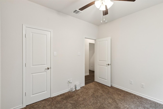 unfurnished bedroom featuring ceiling fan and dark carpet