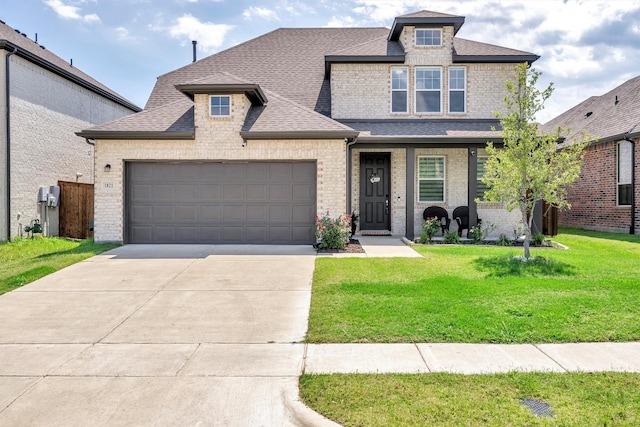 view of front facade with brick siding, a shingled roof, concrete driveway, a front yard, and a garage