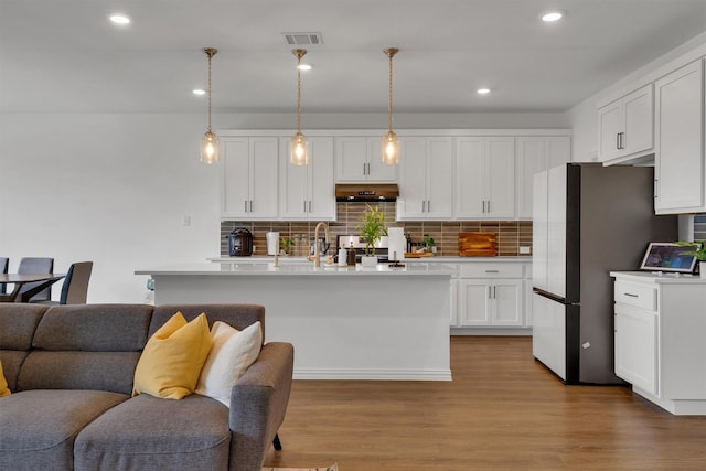 kitchen featuring white cabinetry, decorative light fixtures, exhaust hood, and decorative backsplash