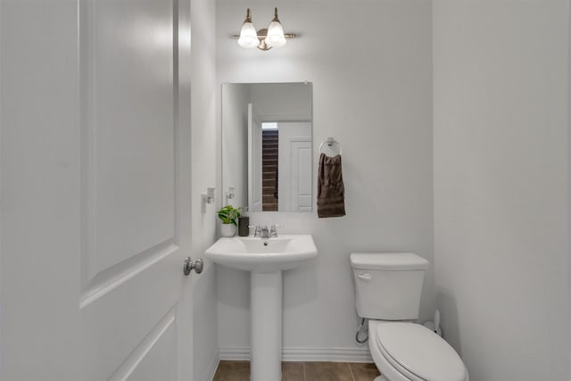 bathroom with toilet, tile patterned floors, and sink