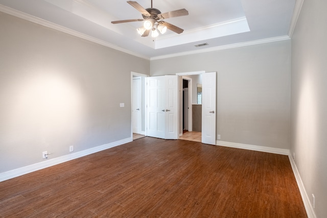 unfurnished room featuring hardwood / wood-style flooring, a raised ceiling, crown molding, and ceiling fan