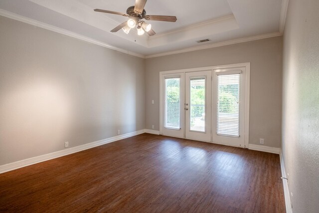 unfurnished room featuring french doors, crown molding, dark wood-type flooring, ceiling fan, and a tray ceiling