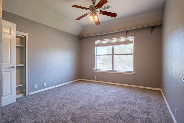 spare room featuring vaulted ceiling, ceiling fan, and carpet flooring