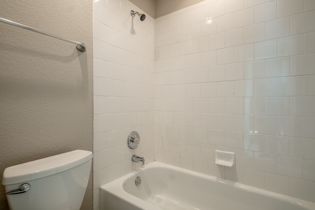 bathroom with toilet and tiled shower / bath