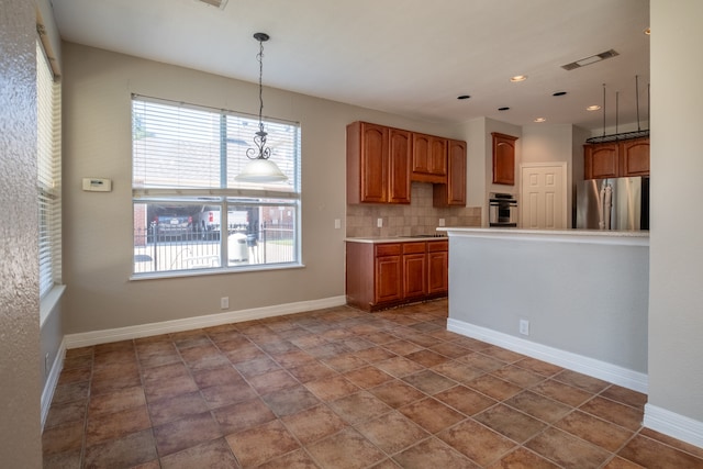 kitchen featuring stainless steel appliances, pendant lighting, backsplash, tile patterned floors, and plenty of natural light