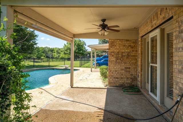 view of pool with a diving board, a patio area, and ceiling fan