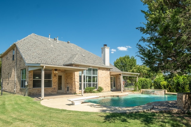 view of swimming pool featuring an in ground hot tub, ceiling fan, a yard, and a patio area