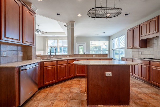 kitchen with light tile patterned floors, hanging light fixtures, sink, and stainless steel dishwasher