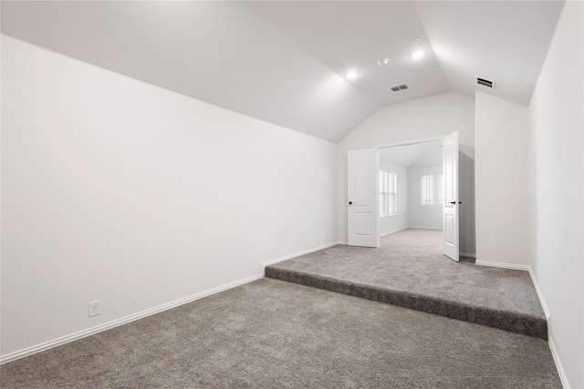 interior space featuring carpet flooring and vaulted ceiling