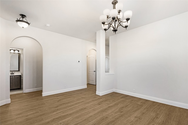 empty room featuring hardwood / wood-style floors and a notable chandelier