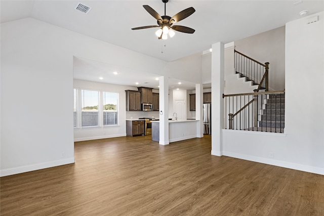 unfurnished living room with ceiling fan, lofted ceiling, sink, and dark hardwood / wood-style floors