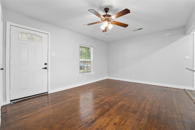 interior space featuring baseboards, visible vents, ceiling fan, and dark wood-type flooring