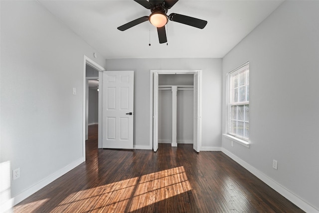 unfurnished bedroom with a closet, dark wood-style flooring, baseboards, and a ceiling fan