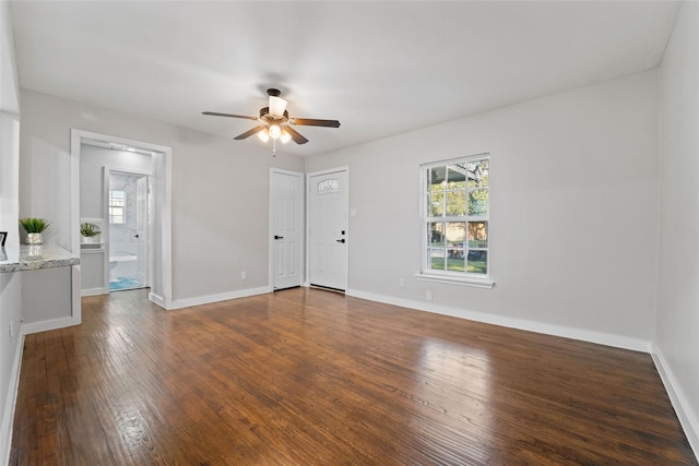 unfurnished room featuring ceiling fan, baseboards, and dark wood finished floors