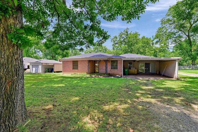 view of front of house featuring a carport and a front lawn