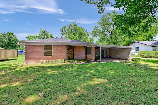 back of property with a carport and a lawn