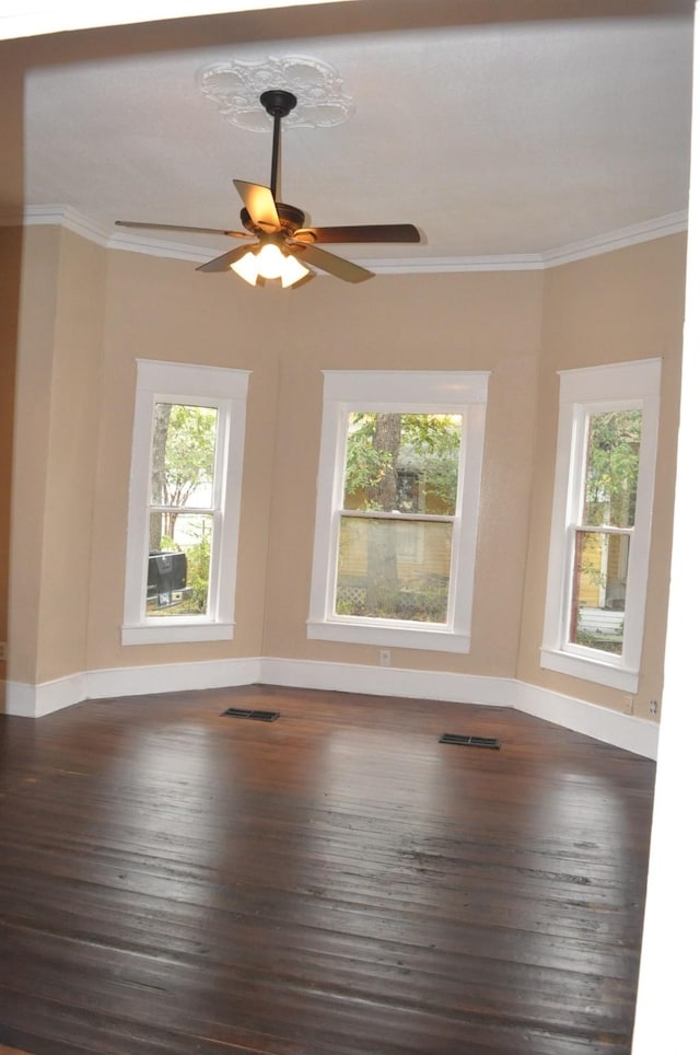 empty room featuring ceiling fan and crown molding