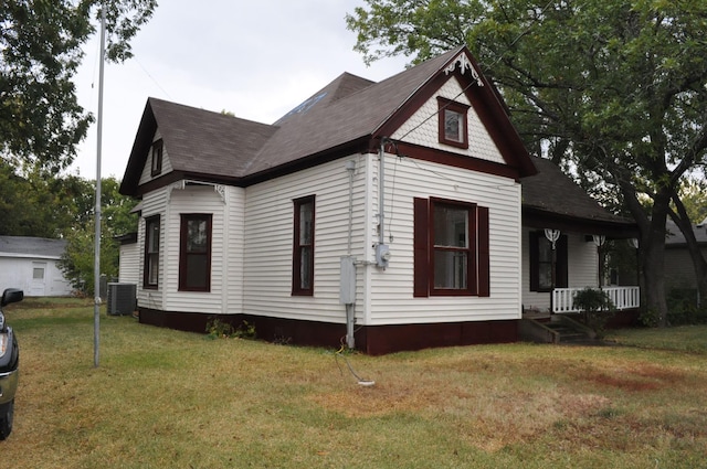 view of property exterior featuring a lawn, covered porch, and central AC