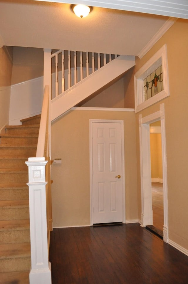 stairway with hardwood / wood-style flooring and ornamental molding