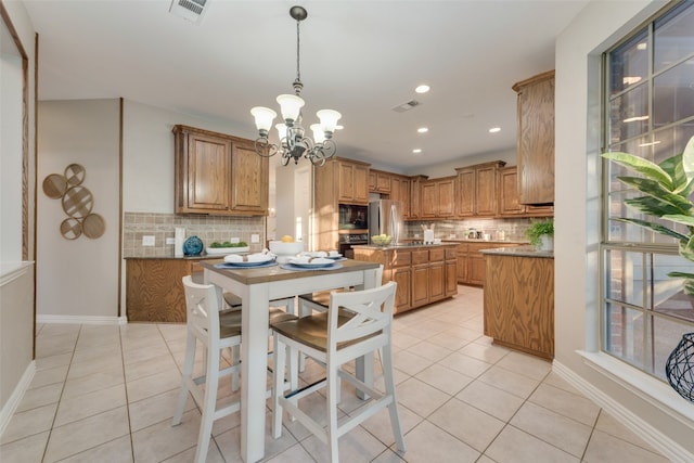 kitchen with decorative backsplash, light tile patterned flooring, hanging light fixtures, and an inviting chandelier