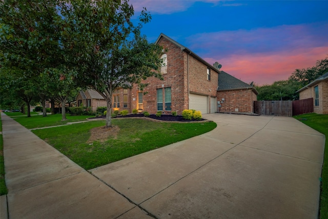 view of front of home with a garage and a yard