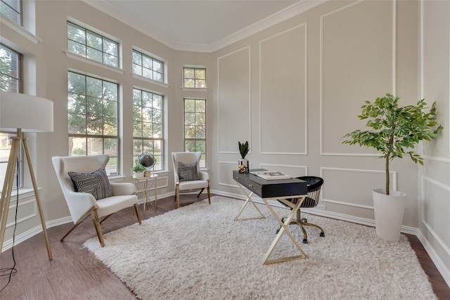 living area featuring crown molding and hardwood / wood-style flooring