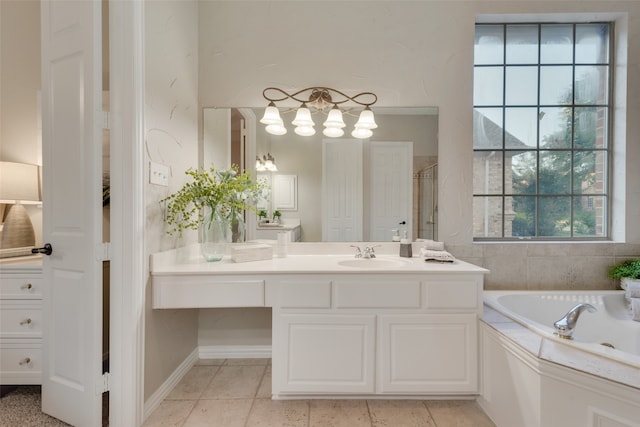 bathroom featuring vanity, tiled bath, and tile patterned flooring