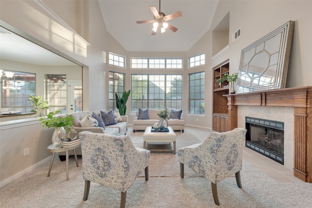 living room featuring carpet floors, high vaulted ceiling, ceiling fan, and a tile fireplace