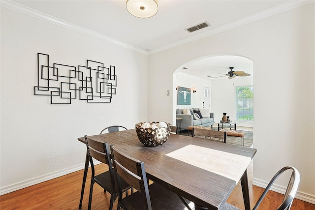 dining space featuring ceiling fan, wood-type flooring, and ornamental molding