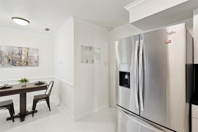 kitchen featuring stainless steel fridge, light tile patterned floors, and ornamental molding