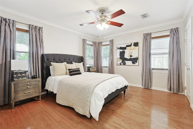 bedroom with multiple windows, ceiling fan, ornamental molding, and hardwood / wood-style flooring