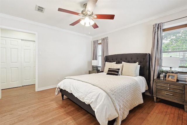 bedroom with a closet, light hardwood / wood-style floors, ceiling fan, and ornamental molding