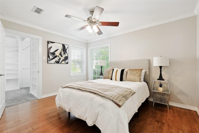 bedroom with ceiling fan, dark hardwood / wood-style floors, and ornamental molding