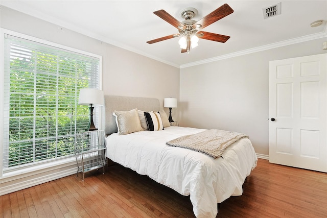 bedroom with wood-type flooring, ceiling fan, and ornamental molding