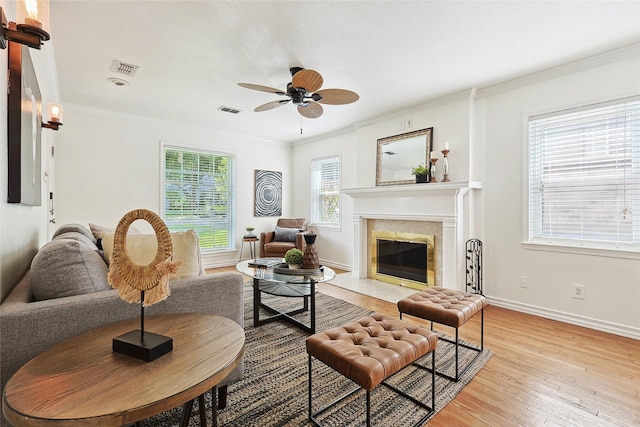 living room featuring light wood-type flooring, ceiling fan, and ornamental molding