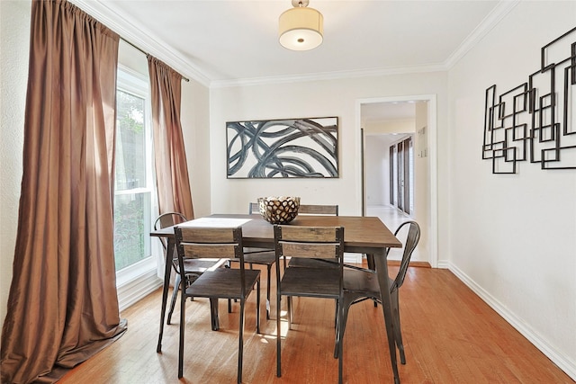 dining area with hardwood / wood-style flooring and ornamental molding