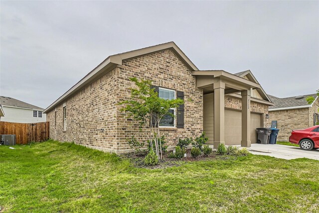 view of front facade featuring a garage, a front lawn, and cooling unit