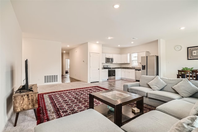 living room featuring light wood-type flooring and sink