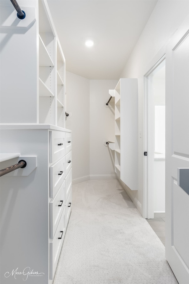 walk in closet featuring light colored carpet