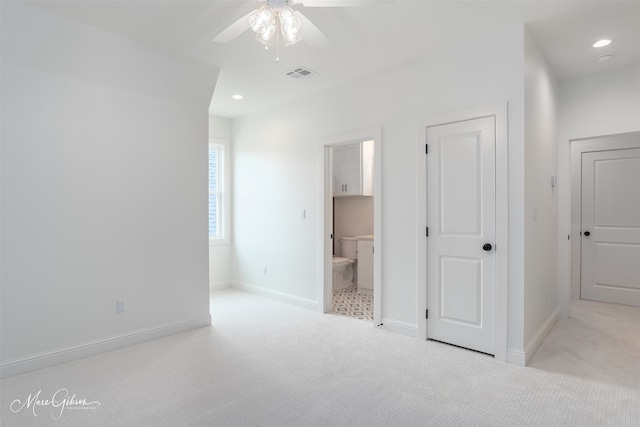 unfurnished bedroom featuring ceiling fan, connected bathroom, and light colored carpet