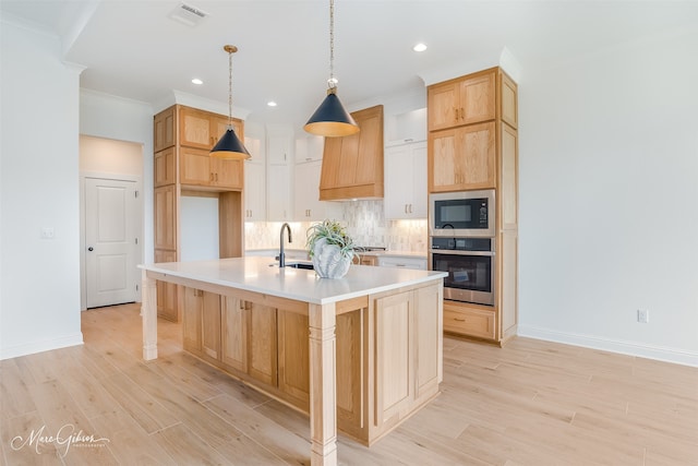 kitchen featuring tasteful backsplash, stainless steel oven, premium range hood, black microwave, and a center island with sink