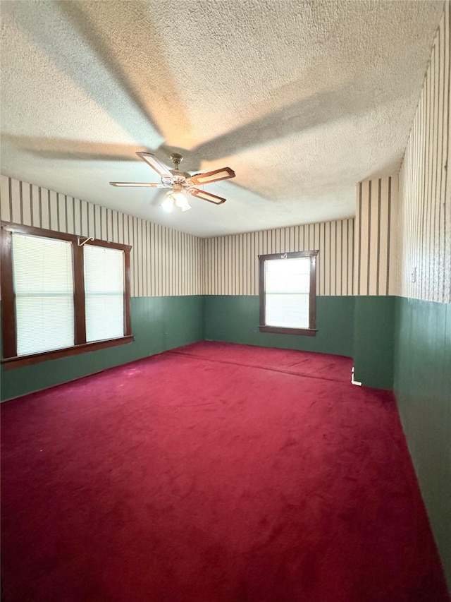 unfurnished room featuring ceiling fan, a textured ceiling, and carpet flooring