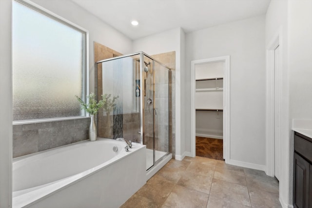 bathroom featuring tile patterned flooring, vanity, and shower with separate bathtub