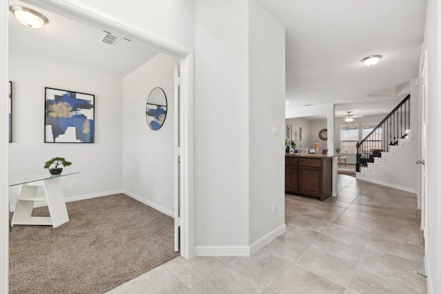 entryway featuring ceiling fan and light colored carpet