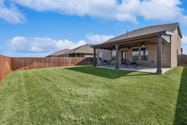 rear view of property featuring ceiling fan, a yard, and a patio