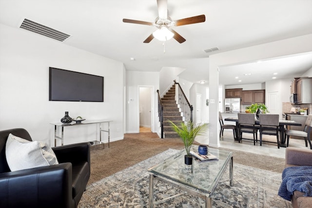 carpeted living room with ceiling fan