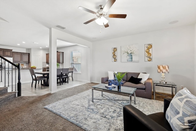 carpeted living room with ceiling fan