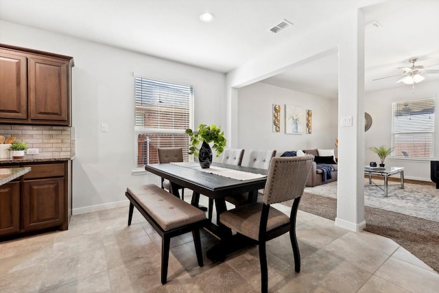 tiled dining space featuring ceiling fan